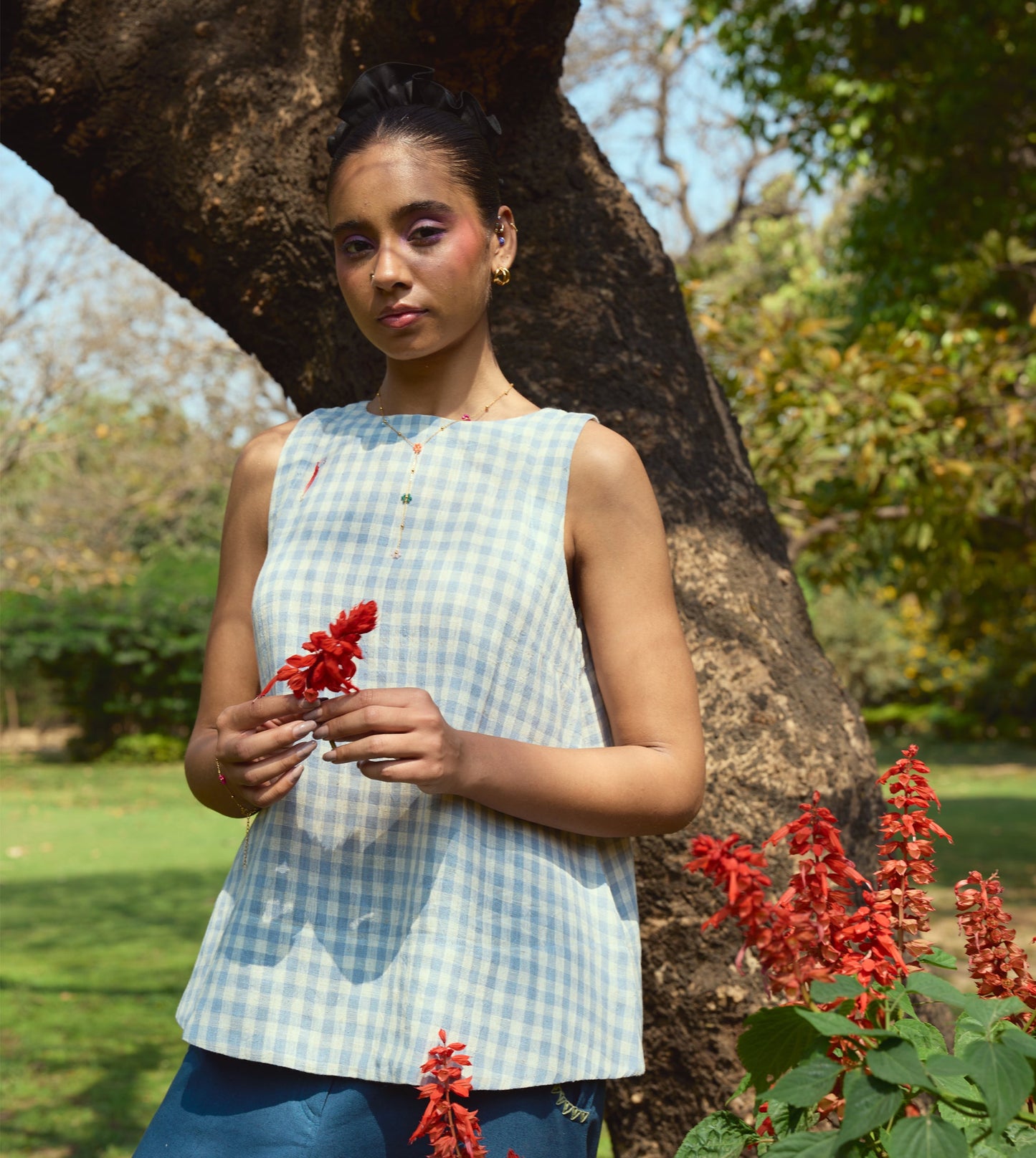 Sleeveless gingham kala cotton trapeze top with brass button closure, made from organic cotton.