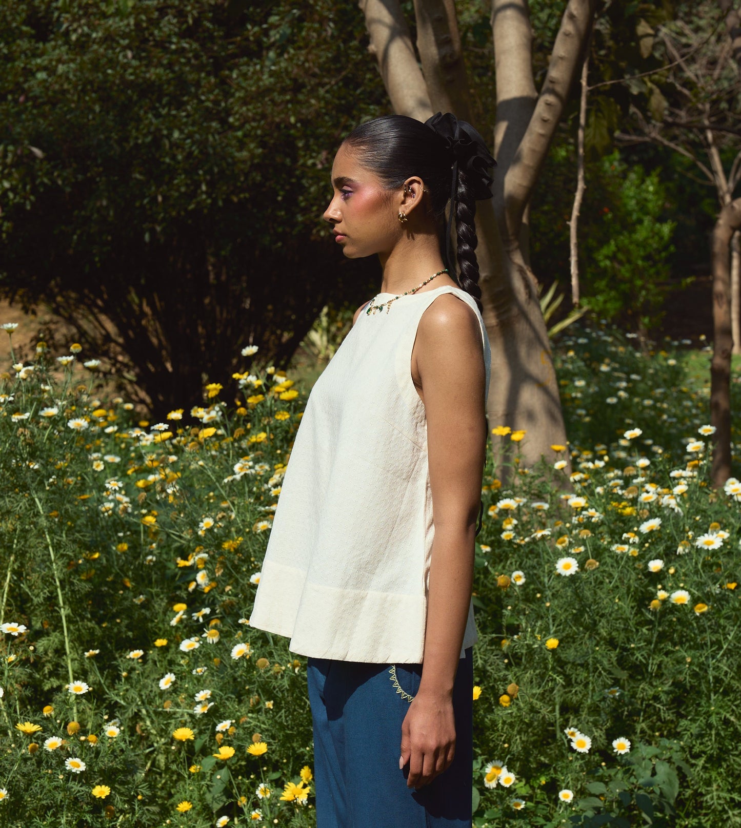 Sleeveless khadi cotton trapeze top with a brass button closure, lightweight and breathable.