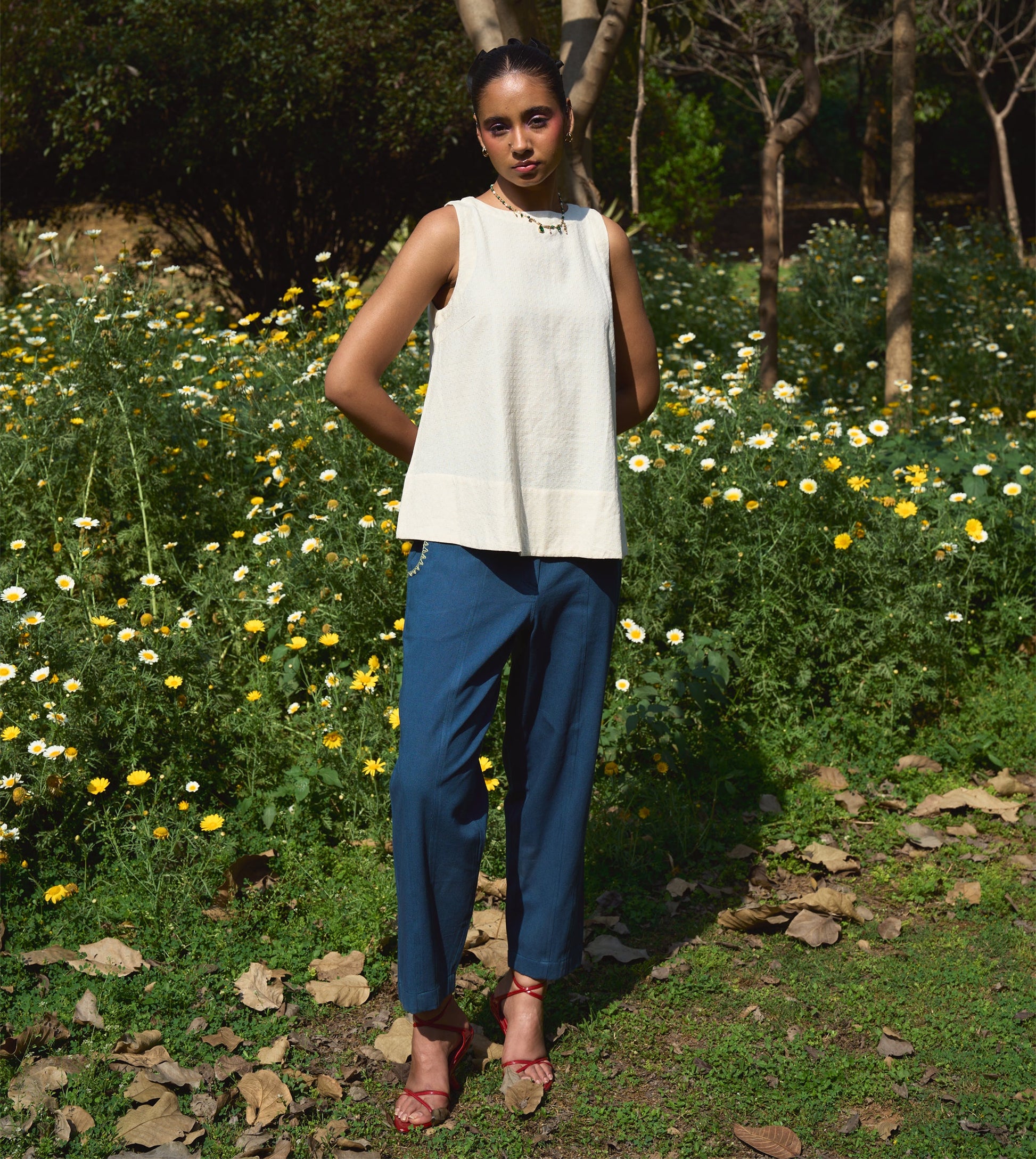 High-waisted thick cotton pants with embroidered pockets, brass button closure, and zippered fly.