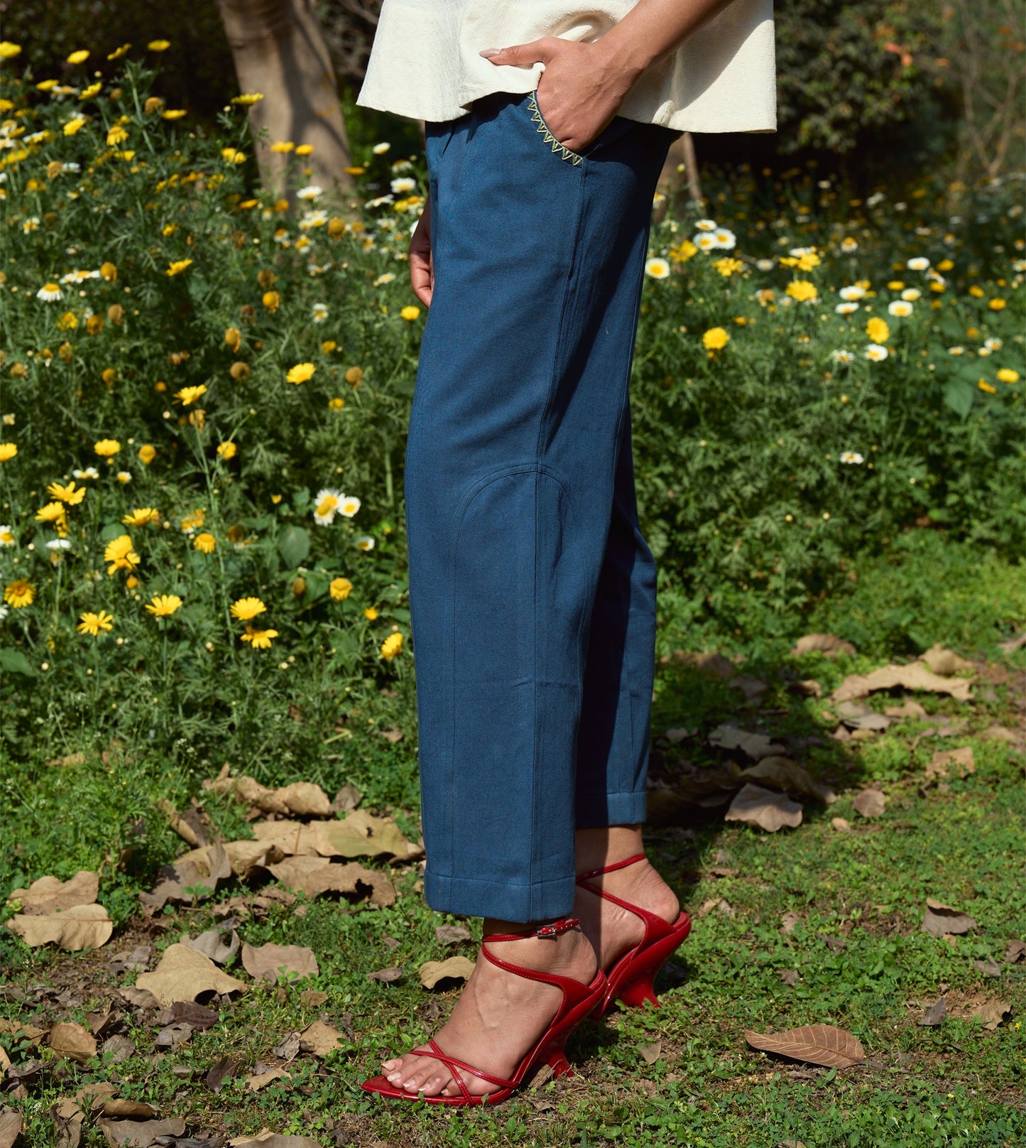 High-waisted thick cotton pants with embroidered pockets, brass button closure, and zippered fly.
